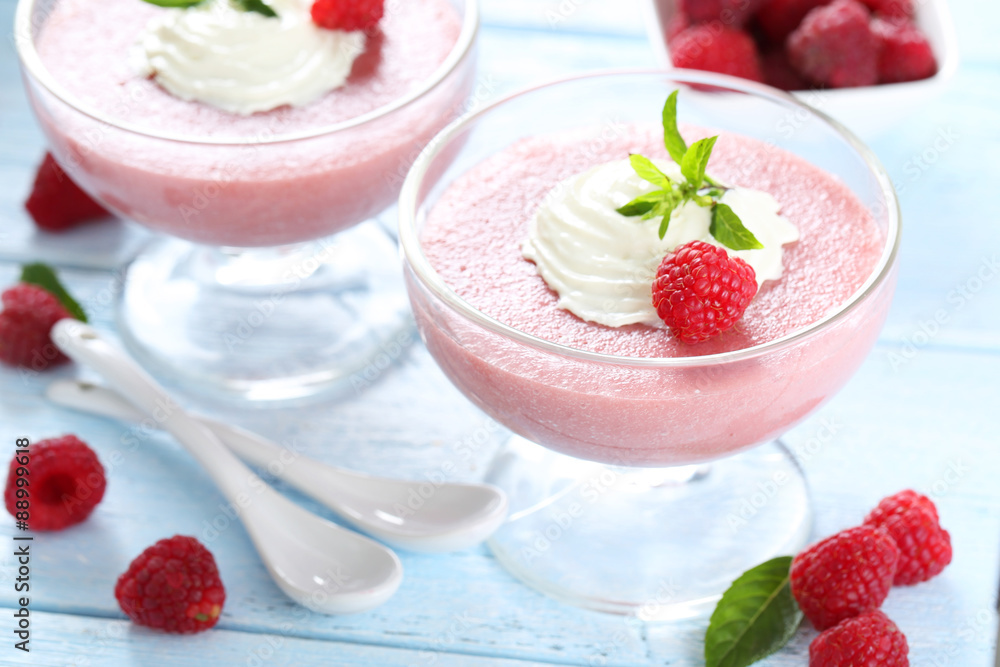 Sweet raspberry mousse in glass on blue wooden table Sweet raspberry mousse in glass on blue wooden table