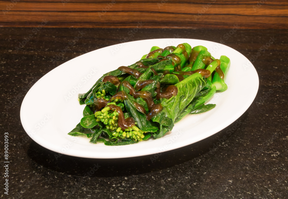 kale fried in oyster sauce on stone table kale fried in oyster sauce on stone table