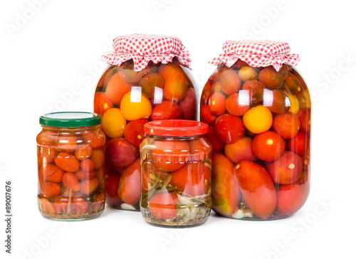 Four jars of pickled tomatoes  isolated on white