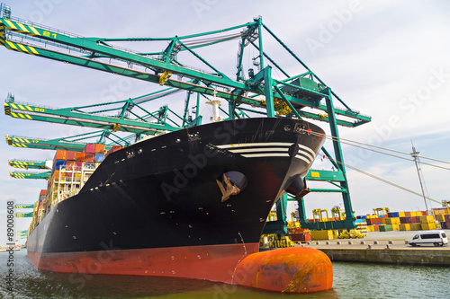 Huge container ship loaded with cranes in Antwerp container terminal
