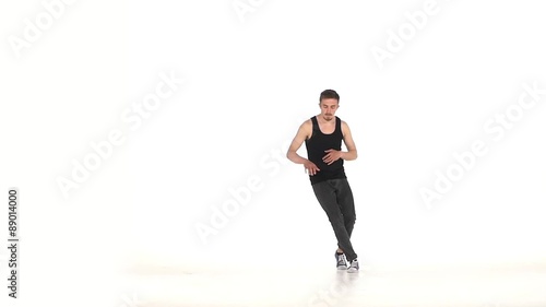 Young b-boy man in shirt doing brake dancing movements, on white photo