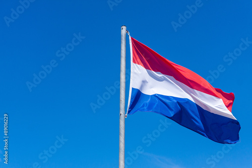 Dutch flag against blue sky
