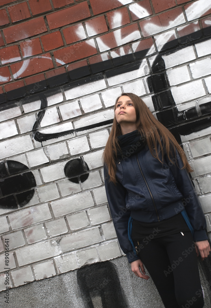 Young teenage girl near a wall