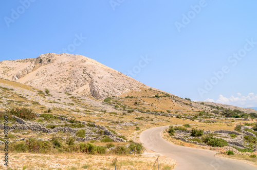 Rocky hills and fences with the road on the island of Krk, Croat