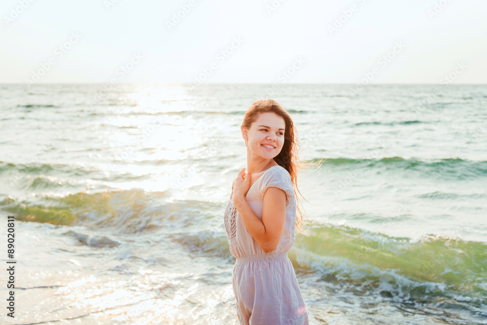 young beautiful caucasian female enjoying the sun on beach during sunrise or sunset young beautiful caucasian female enjoying the sun on beach during sunrise or sunset