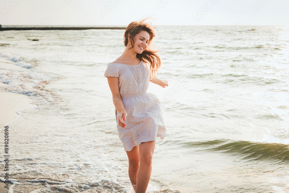 young beautiful caucasian female enjoying the sun on beach during sunrise or sunset young beautiful caucasian female enjoying the sun on beach during sunrise or sunset