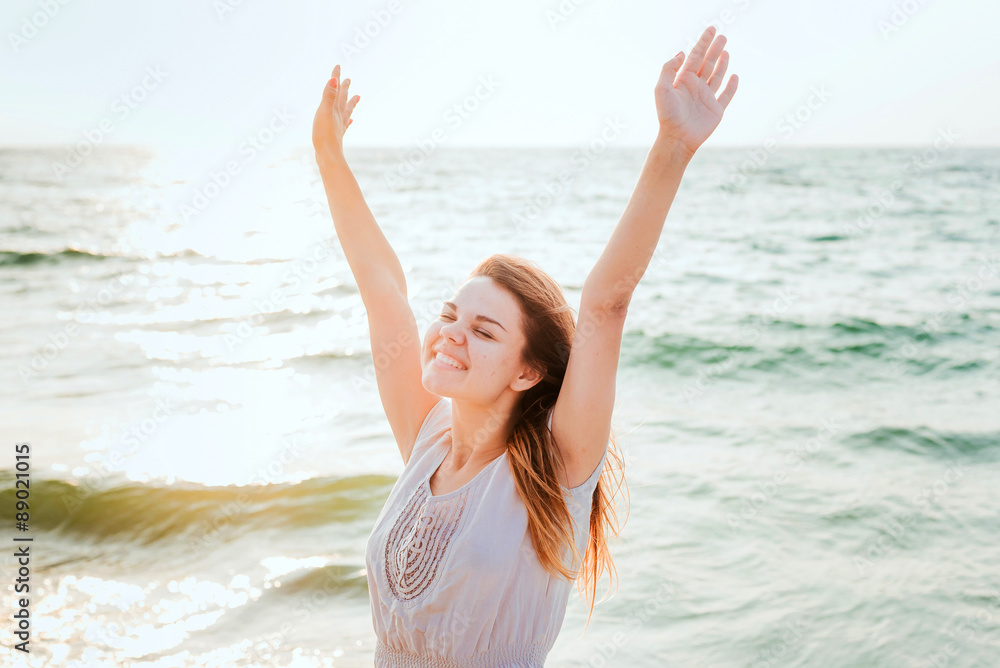 young beautiful caucasian female enjoying the sun on beach during sunrise or sunset