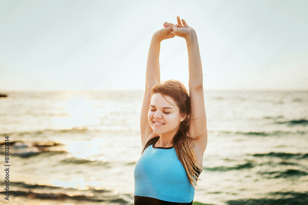 Fitness sport model smiling happy doing exercises during outdoor work out on sunrise. Beautiful caucasian female training outside on seaside in the morning Fitness sport model smiling happy doing exercises during outdoor work out on sunrise. Beautiful caucasian female training outside on seaside in the morning
