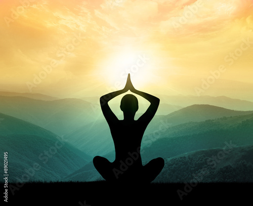 Yoga and meditation. Silhouette of man in moontains.