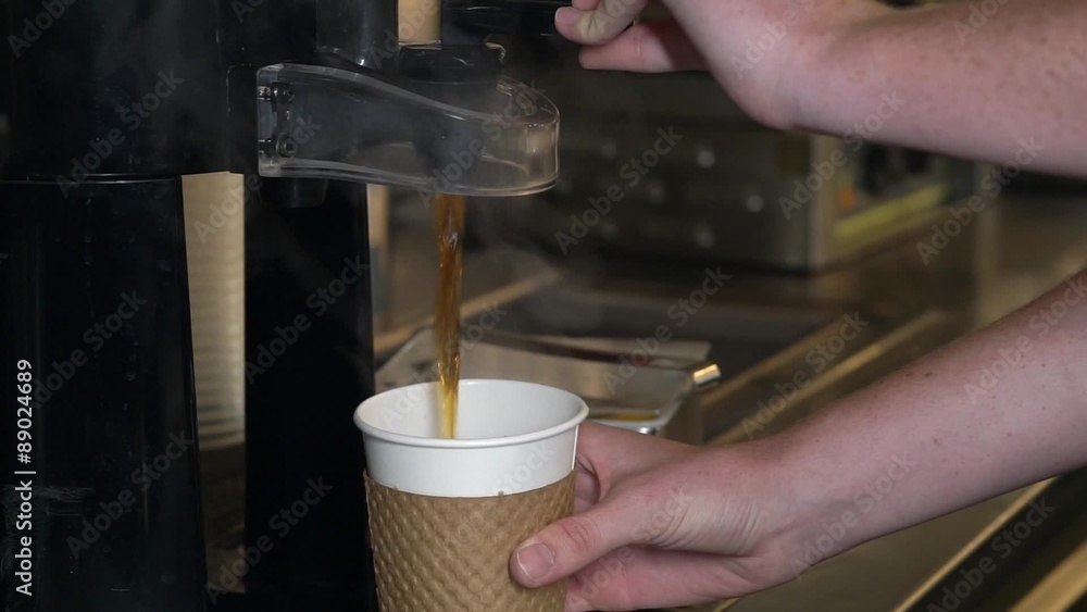 Pouring hot coffee into paper to go cup
