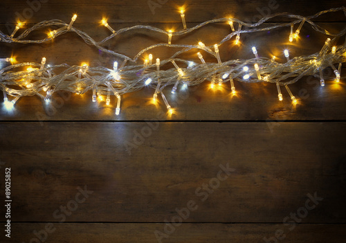 abstract photo of Christmas warm gold garland lights on wooden background