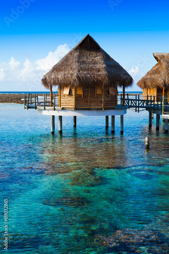 houses over the transparent quiet sea water. Tahiti