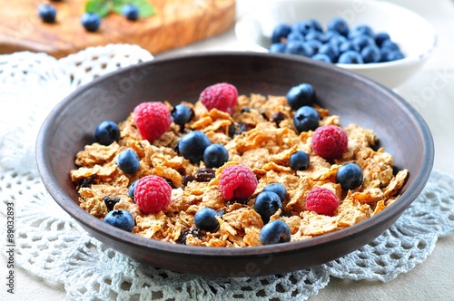 homemade granola with fresh blueberries, raspberries, raisins, milk and honey. Healthy Breakfast