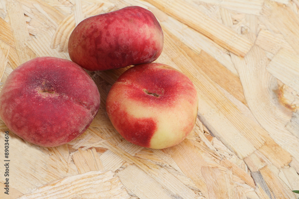 The ripe peaches lying on a wooden basis in a garden The ripe peaches lying on a wooden basis in a garden