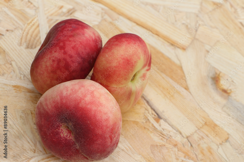 The ripe peaches lying on a wooden basis in a garden The ripe peaches lying on a wooden basis in a garden