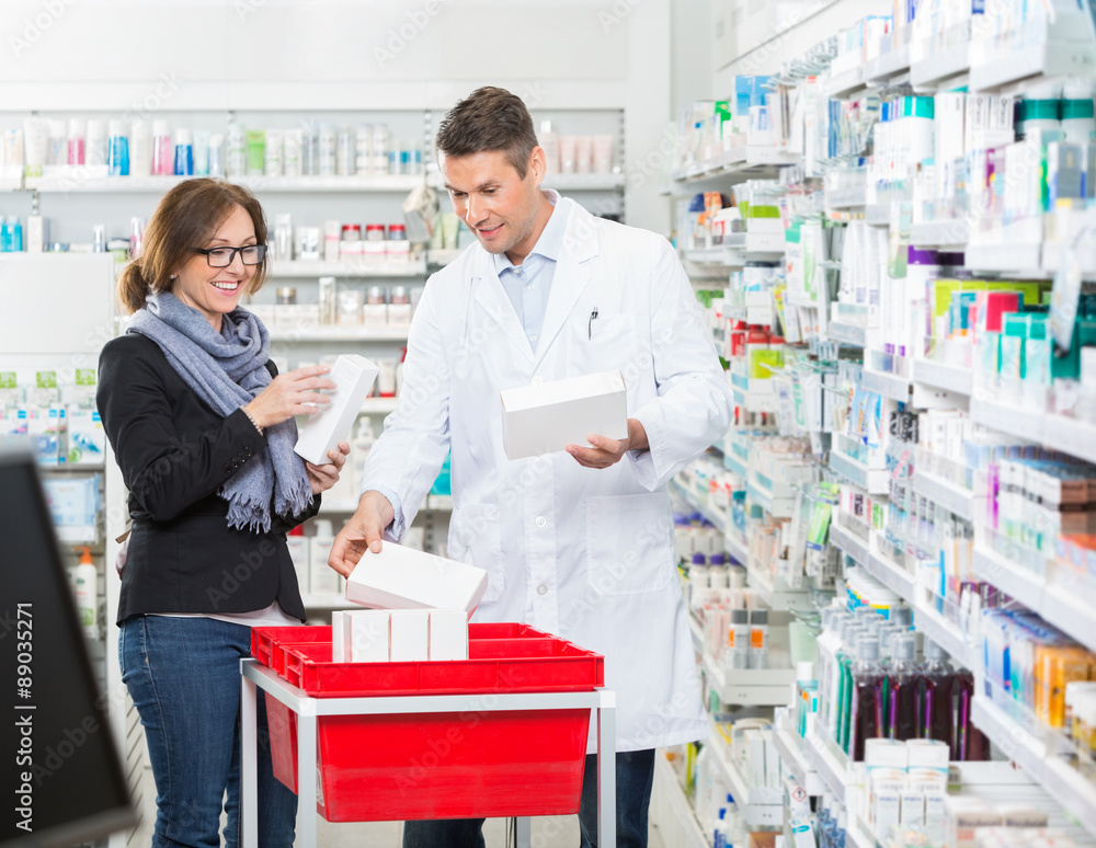 Obraz premium Male Chemist Showing Medicines To Female Customer