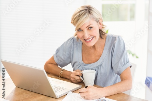 Smiling businesswoman working on a laptop