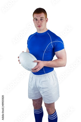 Smiling rugby player holding rugby ball