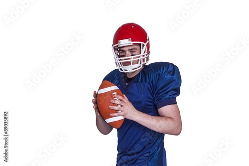 Serious american football player holding a ball
