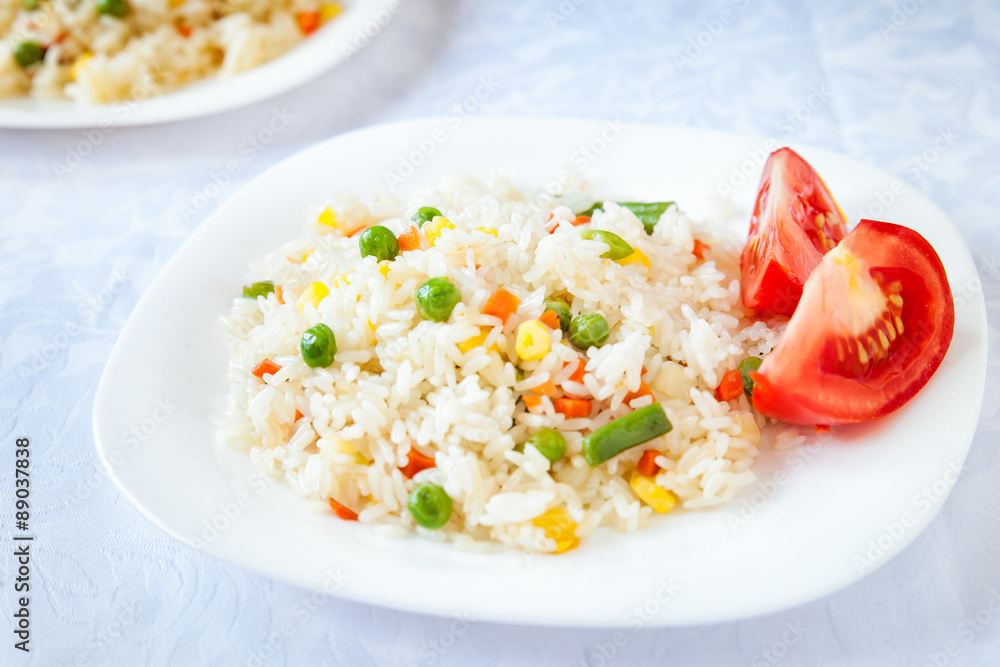 Rice with fried vegetables served with fresh tomato Rice with fried vegetables served with fresh tomato