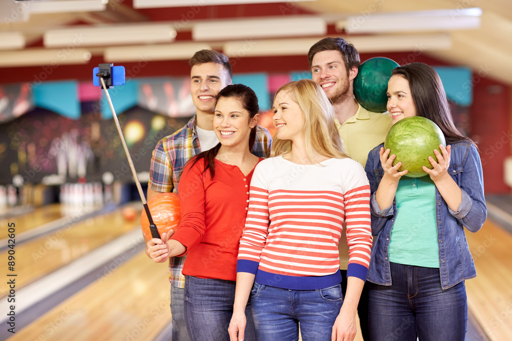 happy friends taking selfie in bowling club