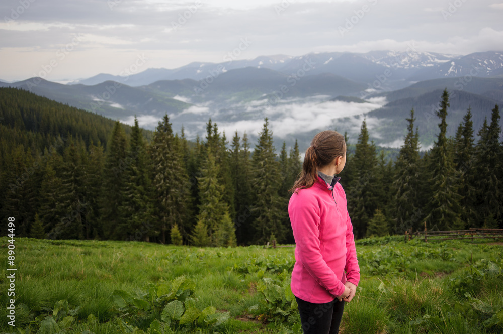Naklejka premium young girl in the mountains looking around