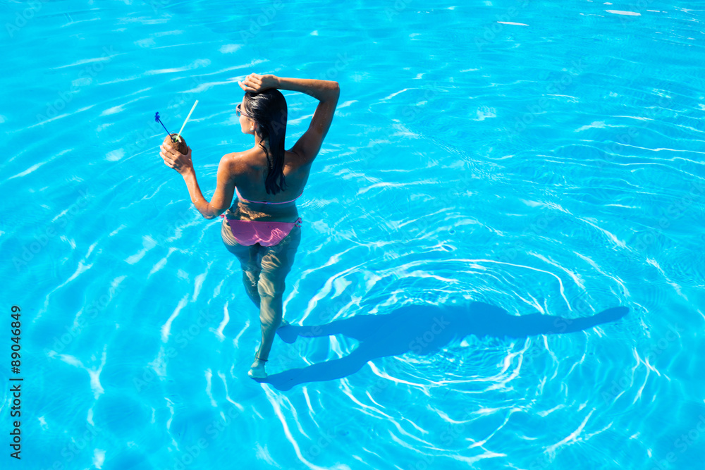 Back view portrait of a woman standing in swim pool