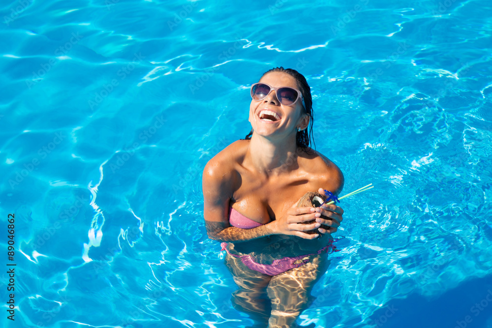 Laughing woman standing in swim pool