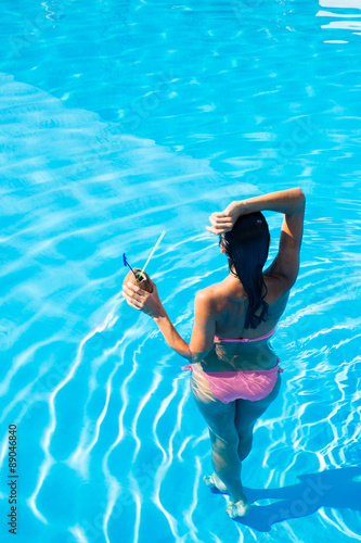 Back view portrait of a girl standing in swim pool