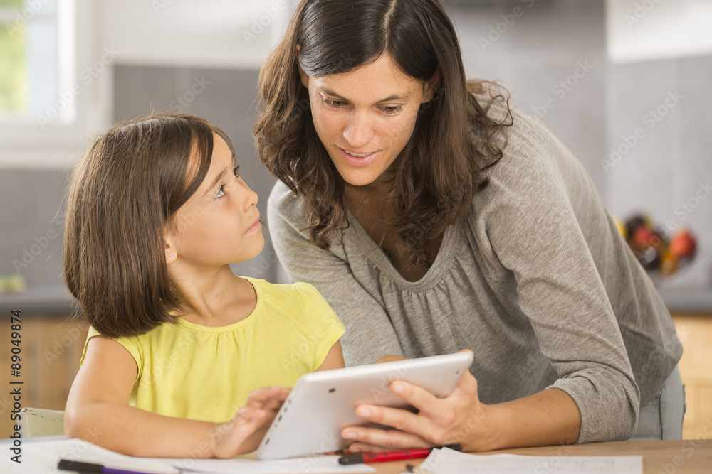 mother and daughter doing homework with a tablet mother and daughter doing homework with a tablet