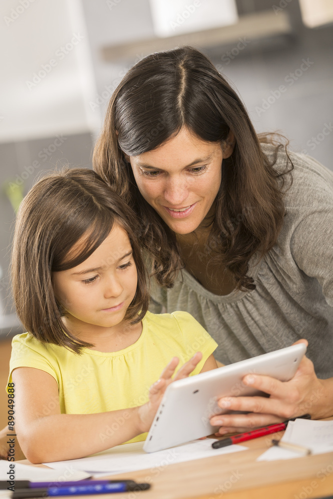 mother and daughter doing homework with a tablet mother and daughter doing homework with a tablet