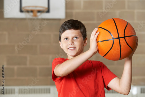 Boy Shooting During Basketball Match In School Gym
