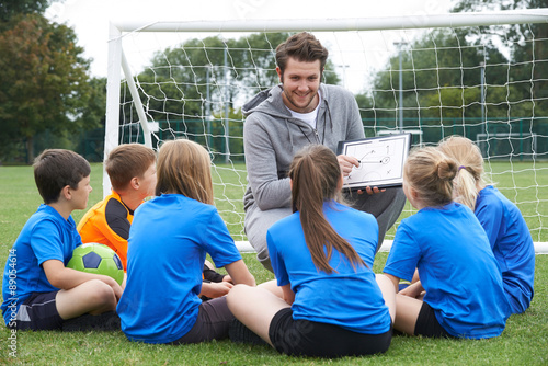 Canvas Print Coach Giving Team Talk To Elementary School Soccer Team