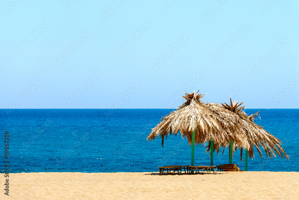 Blue sea, golden sand and sunbeds on the beach