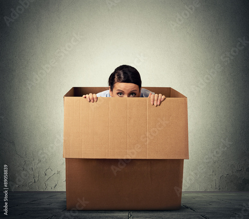 Young woman hiding in a carton box