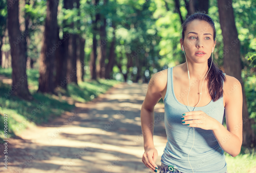 Young woman running In countryside wearing earphones Young woman running In countryside wearing earphones