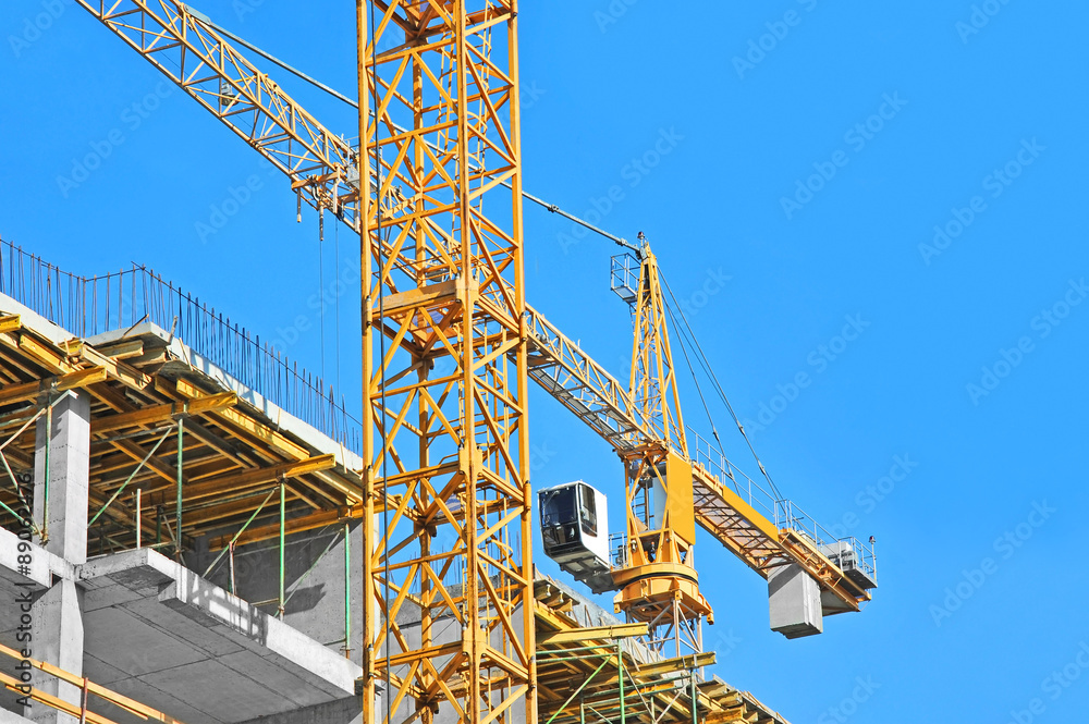 Crane and building construction site against blue sky Crane and building construction site against blue sky