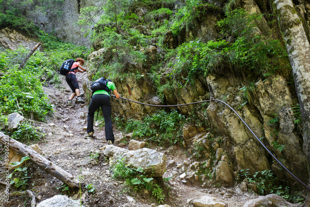 Hikers on a perilous trail, holding the safety line