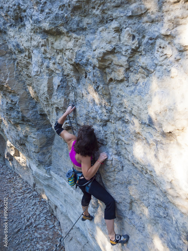 Fototapeta Naklejka Na Ścianę i Meble -  Young woman with rope climbs on the rock.