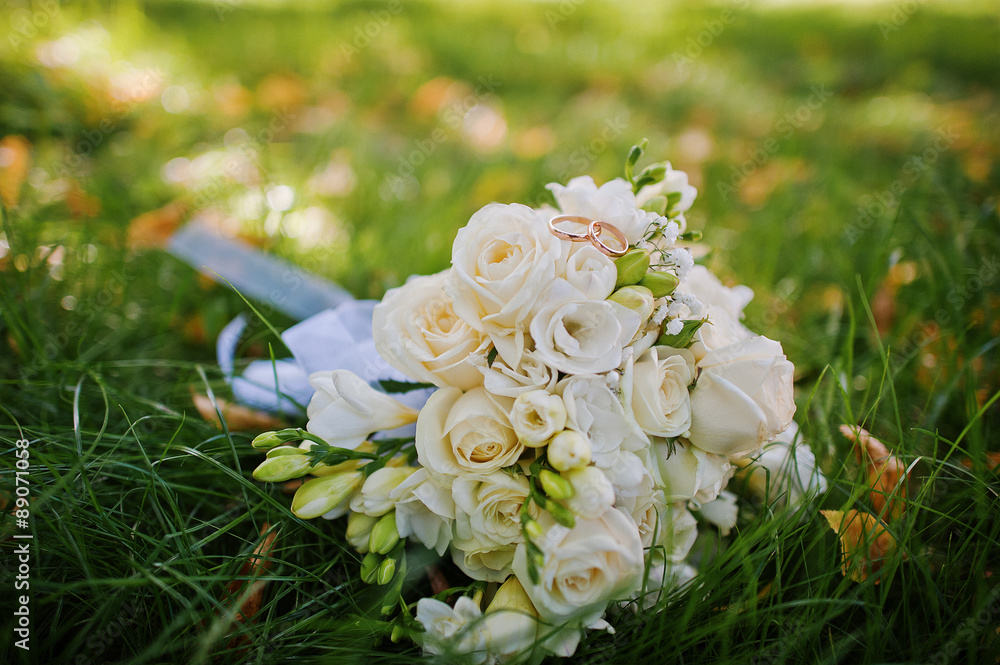 wedding bouquet with engagement rings on green grass wedding bouquet with engagement rings on green grass