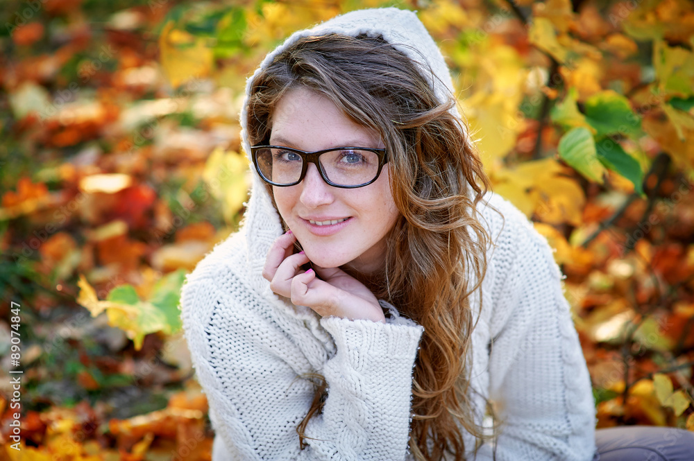 beautiful woman in glasses sitting on yellow leaves beautiful woman in glasses sitting on yellow leaves