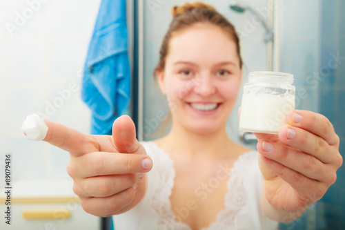 Woman with moisturizing skin cream. Skincare.