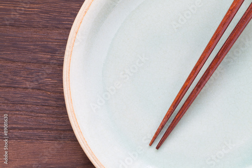 Wood brown chopsticks and celadon green ceramic on wood table background