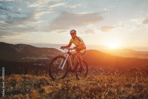 Fototapeta Naklejka Na Ścianę i Meble -  mountain bike cyclist riding track on grass rocky trail above su