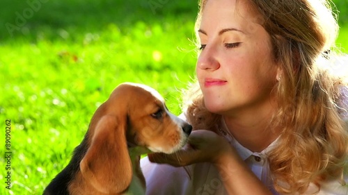  happy woman with a dog beagle playing on nature. Close up photo