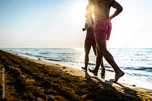 Coppia che corre sulla spiaggia photo