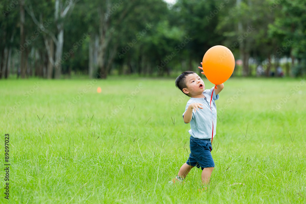 Small kid play with orange balloon Small kid play with orange balloon