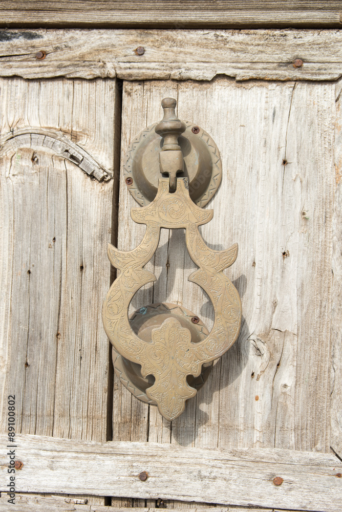 Old knocker on a wood door, Morocco style Old knocker on a wood door, Morocco style