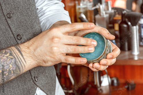 Close up of barbers hand and a gel jar 