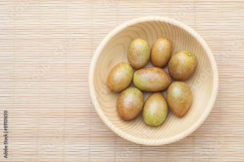 Fresh wampee fruit in wooden bowl. Wampee fruit is a tropical fruit native to southern China.
